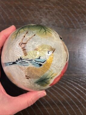 a hand-painted decorative ball orb featuring flowers and birds